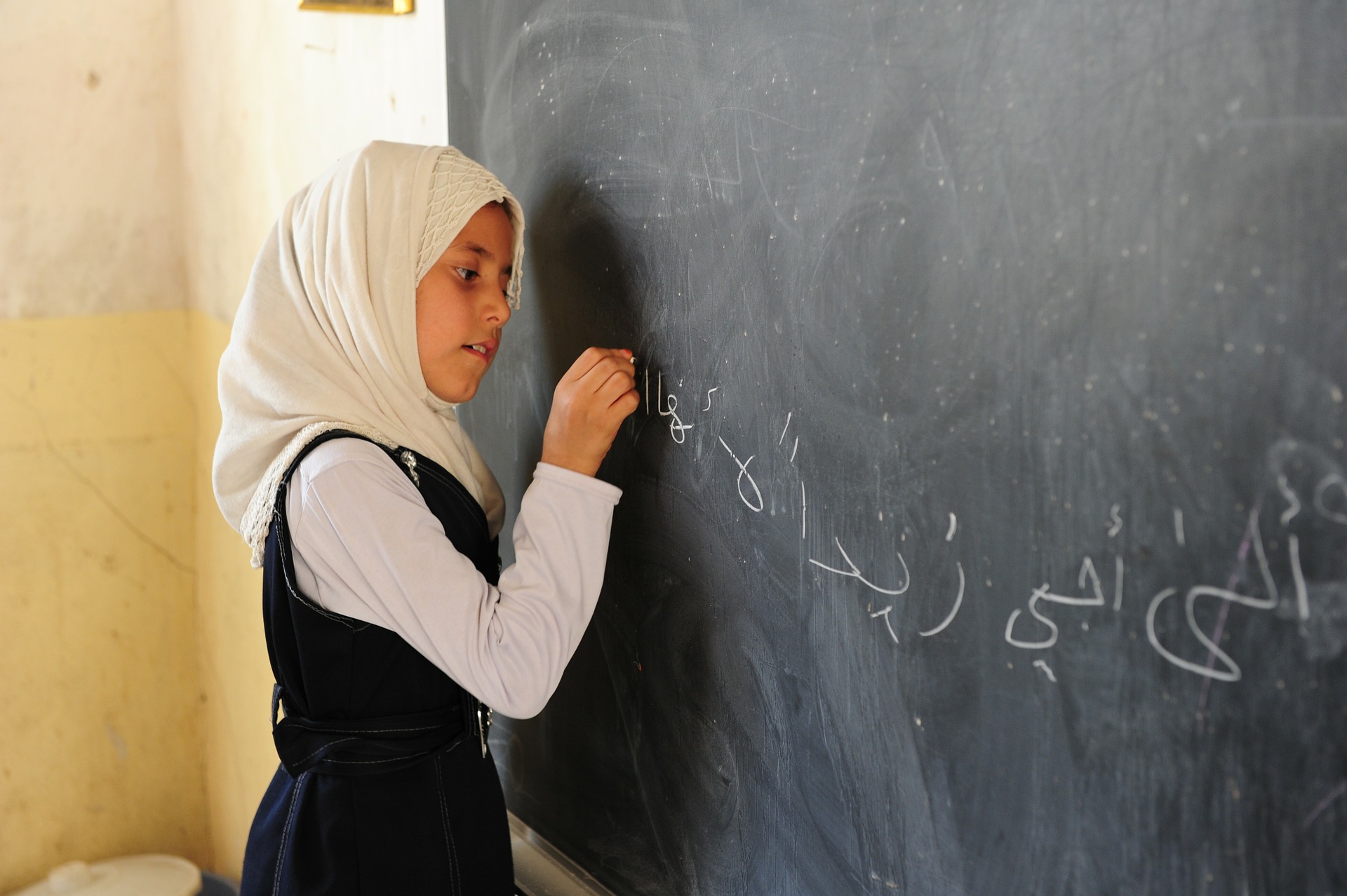Girl writing on chalkboard
